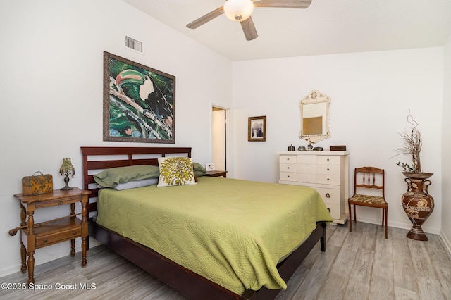 bedroom featuring visible vents, a ceiling fan, baseboards, and wood finished floors