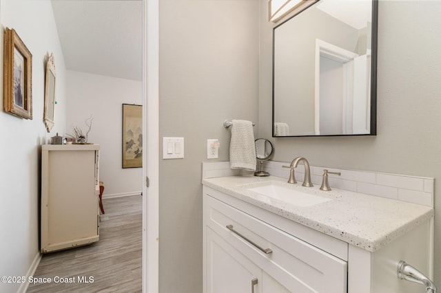 bathroom featuring vanity, baseboards, and wood finished floors