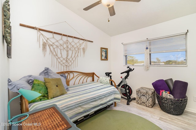 bedroom with ceiling fan, baseboards, wood finished floors, and vaulted ceiling