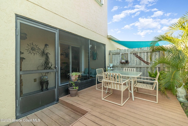 deck featuring outdoor dining area and fence