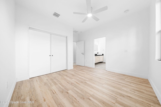 unfurnished bedroom with a closet, visible vents, light wood-type flooring, and baseboards