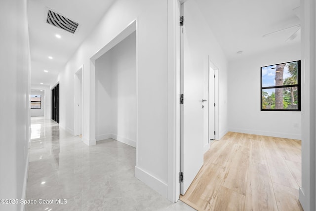 hall with recessed lighting, visible vents, and baseboards