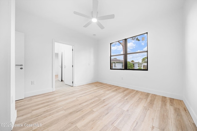 empty room featuring light wood finished floors, baseboards, and a ceiling fan