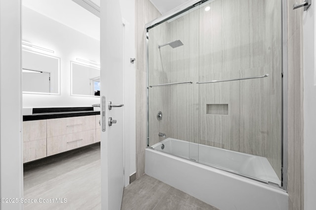 bathroom with vanity, wood finished floors, and enclosed tub / shower combo