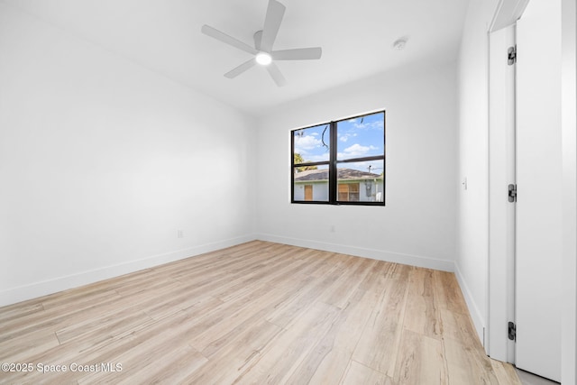 spare room featuring light wood finished floors, baseboards, and ceiling fan