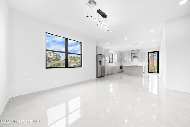 unfurnished living room with recessed lighting, visible vents, and baseboards