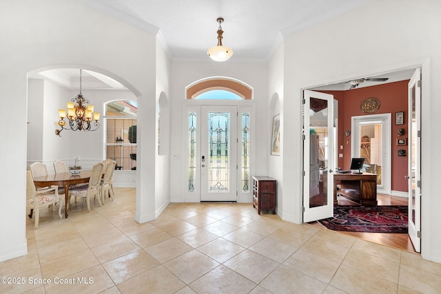 3338 Cappio Dr, Melbourne, FL 32940 - foyer entrance featuring light tile patterned floors, baseboards, arched walkways, a chandelier, and crown molding