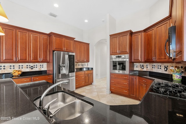 3338 Cappio Dr, Melbourne, FL 32940 - kitchen with tasteful backsplash, visible vents, stainless steel appliances, arched walkways, and a sink