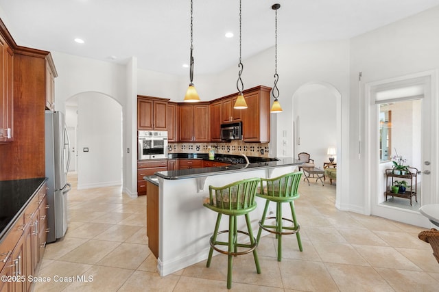 3338 Cappio Dr, Melbourne, FL 32940 - kitchen featuring light tile patterned floors, tasteful backsplash, arched walkways, appliances with stainless steel finishes, and dark countertops
