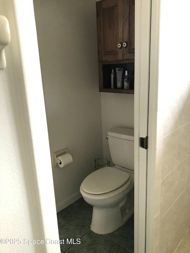 bathroom featuring tile patterned flooring, toilet, and baseboards