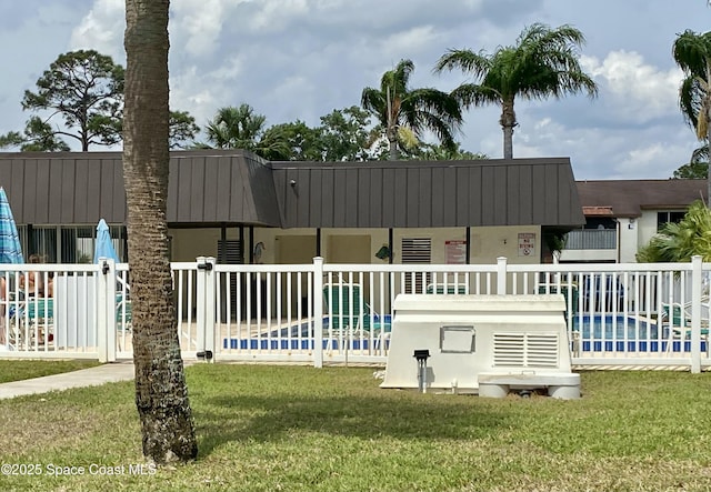 view of swimming pool with a yard and fence