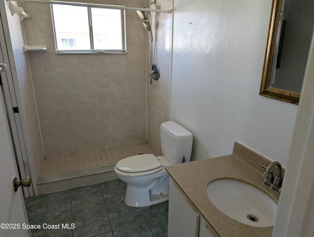 full bathroom with tile patterned flooring, a stall shower, toilet, and vanity