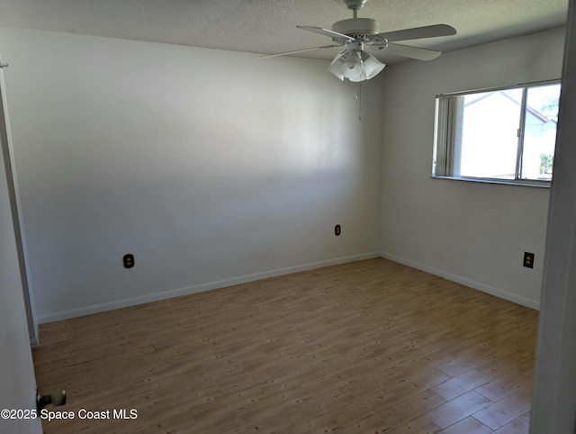 unfurnished room with baseboards, a textured ceiling, ceiling fan, and wood finished floors