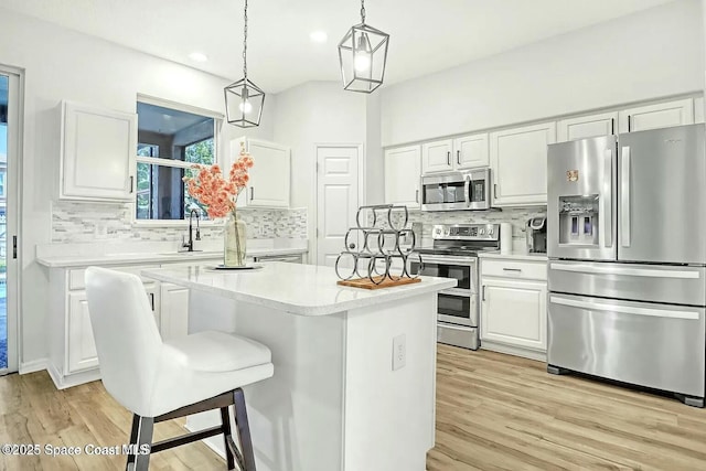 4026 Four Lakes Dr, Melbourne, FL 32940 - kitchen with white cabinets, stainless steel appliances, a center island, and decorative backsplash