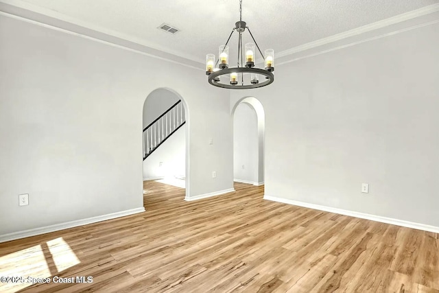 4026 Four Lakes Dr, Melbourne, FL 32940 - unfurnished room with ornamental molding, a chandelier, arched walkways, light wood finished floors, and visible vents