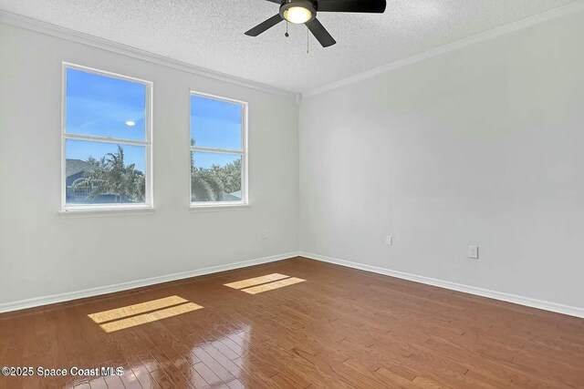 4026 Four Lakes Dr, Melbourne, FL 32940 - unfurnished room featuring baseboards, a textured ceiling, crown molding, and wood finished floors