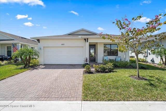 ranch-style house with a front lawn, decorative driveway, an attached garage, and stucco siding