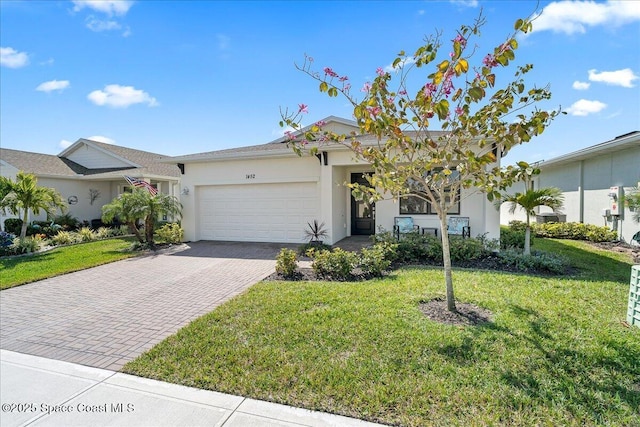 ranch-style home with stucco siding, an attached garage, decorative driveway, and a front lawn