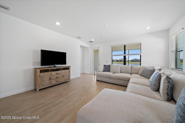 living room featuring plenty of natural light, recessed lighting, visible vents, and light wood finished floors