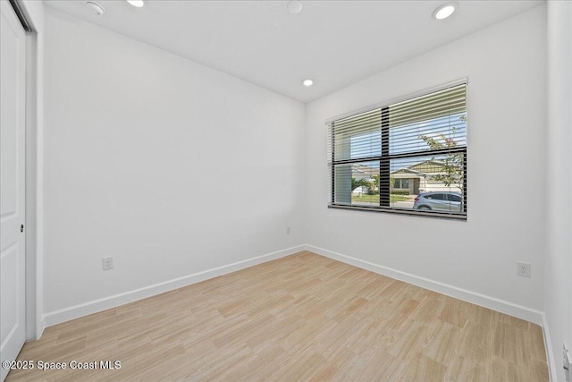 unfurnished room with recessed lighting, wood finished floors, and baseboards