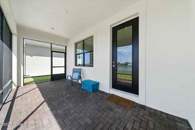 unfurnished sunroom featuring a water view