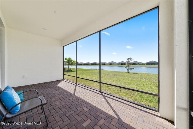 unfurnished sunroom with a water view and a wealth of natural light