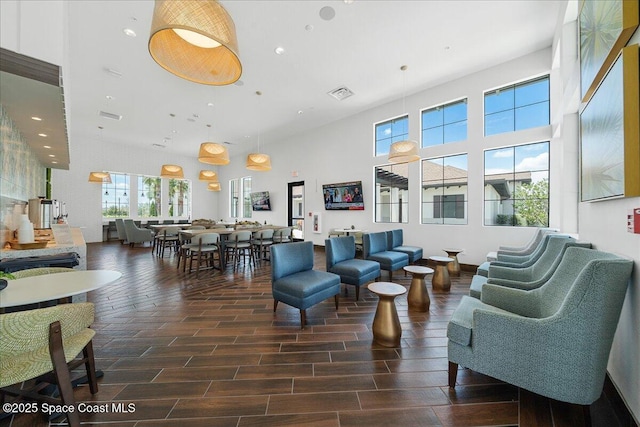 living room with recessed lighting, visible vents, a high ceiling, and wood tiled floor