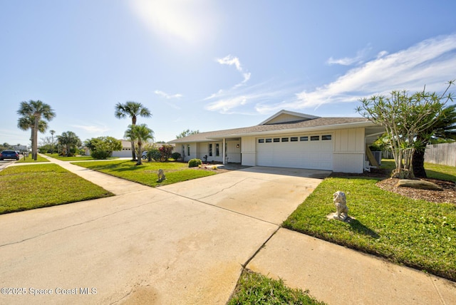 ranch-style home featuring brick siding, a front lawn, fence, a garage, and driveway