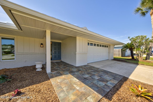 exterior space featuring brick siding, board and batten siding, concrete driveway, and an attached garage