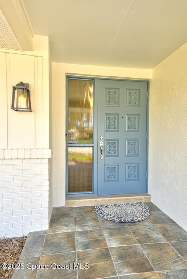 entrance to property with stucco siding and brick siding