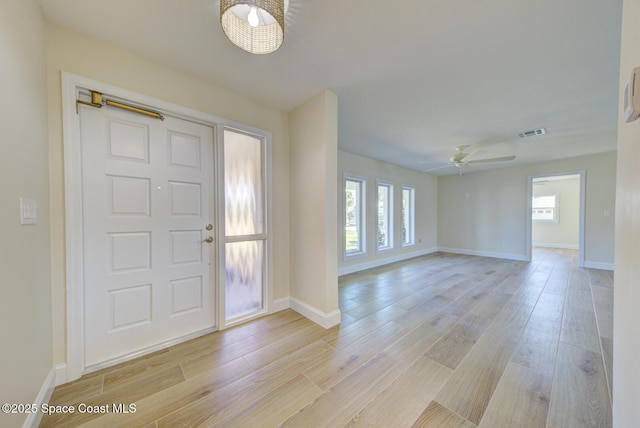 entrance foyer with light wood finished floors, visible vents, ceiling fan, and baseboards