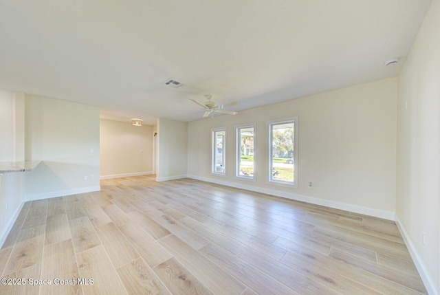 spare room featuring visible vents, light wood-style flooring, baseboards, and ceiling fan