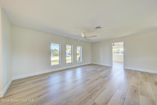 unfurnished room featuring baseboards, visible vents, light wood-type flooring, and ceiling fan