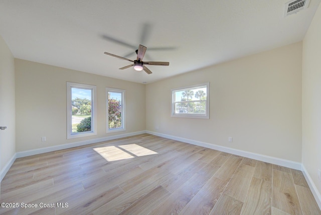 empty room featuring light wood finished floors, visible vents, baseboards, and ceiling fan