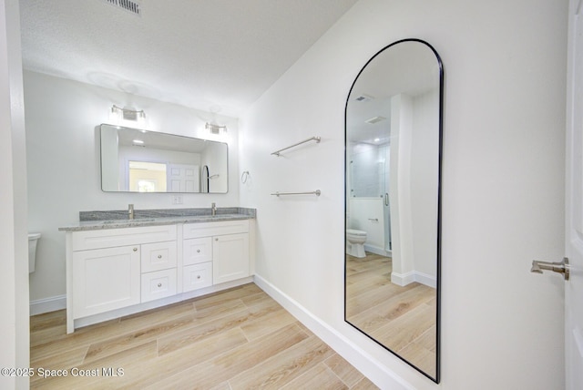 bathroom featuring a sink, toilet, and wood finished floors