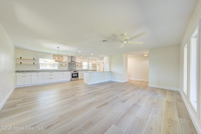 unfurnished living room with visible vents, baseboards, ceiling fan, and light wood finished floors