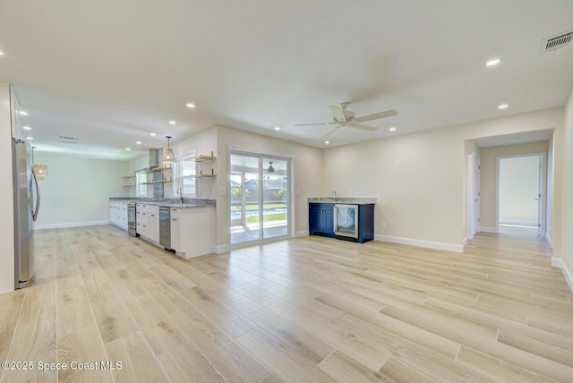 unfurnished living room with light wood-type flooring, visible vents, recessed lighting, baseboards, and ceiling fan