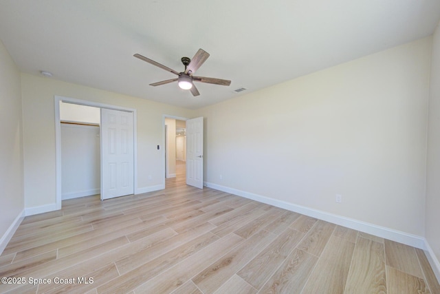 unfurnished bedroom featuring a closet, visible vents, light wood-style flooring, and baseboards