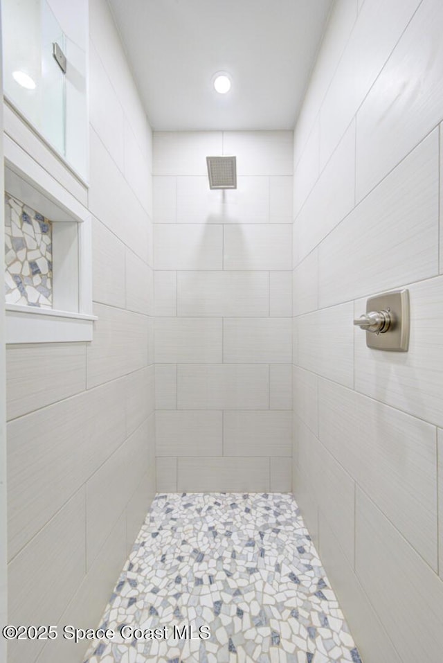 bathroom featuring a tile shower and visible vents