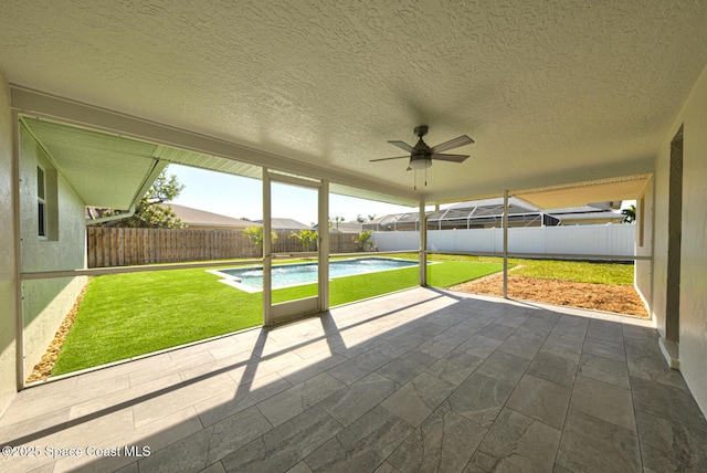 unfurnished sunroom featuring ceiling fan