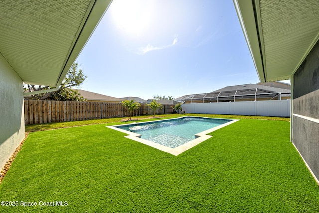 view of swimming pool with a lawn, a fenced in pool, and a fenced backyard