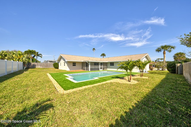 rear view of house with a fenced in pool, a fenced backyard, a lawn, and stucco siding