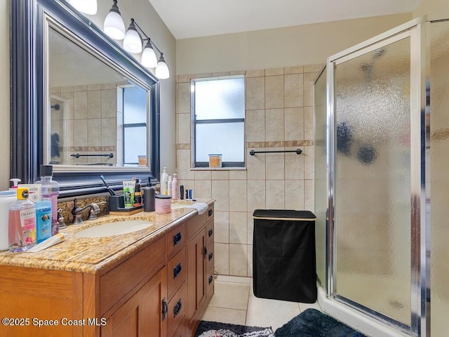 full bath featuring tile patterned flooring, tile walls, vanity, and a shower stall