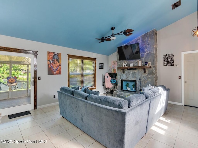 living room featuring lofted ceiling, light tile patterned flooring, visible vents, and ceiling fan