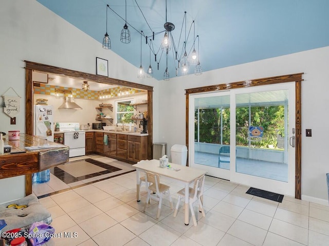 dining area with a high ceiling and light tile patterned flooring