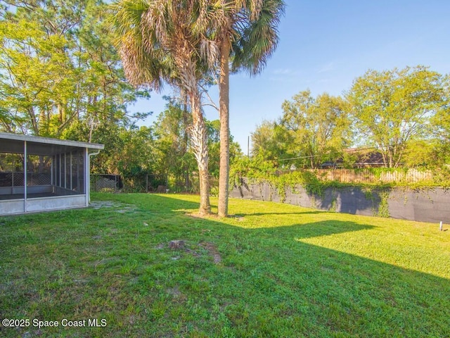 view of yard featuring a fenced backyard and a sunroom