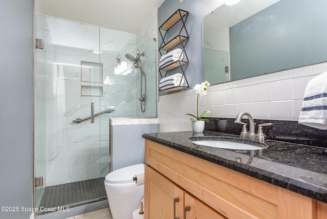 bathroom featuring vanity, toilet, tasteful backsplash, and a marble finish shower