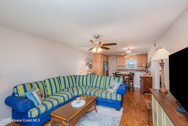 living area with wood finished floors and ceiling fan