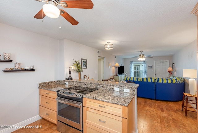 kitchen featuring stainless steel range with electric stovetop, light brown cabinetry, a ceiling fan, light wood-style floors, and a peninsula