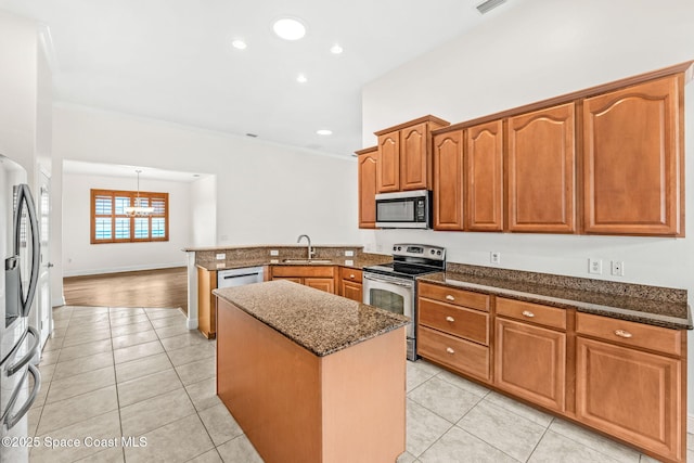 3980 Funston Cir, Melbourne, FL 32940 - kitchen featuring a sink, a peninsula, stainless steel appliances, dark stone counters, and light tile patterned flooring